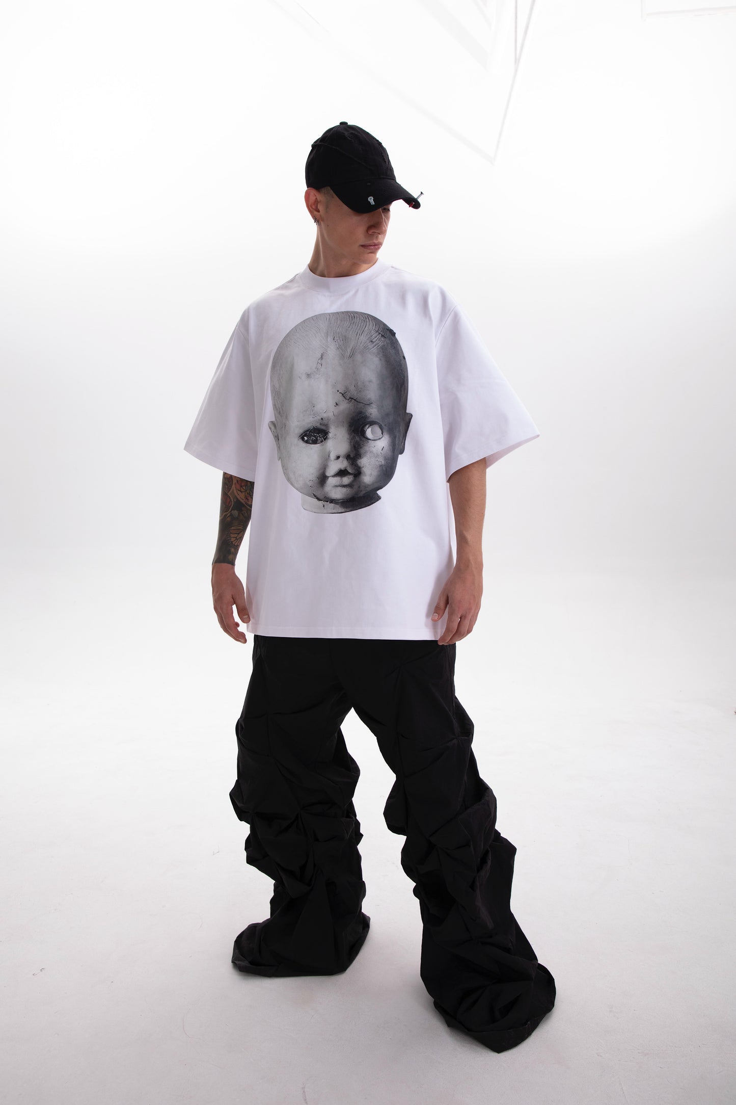 Model wearing the Baby Face white t-shirt , styled in a dark aesthetic on a white background