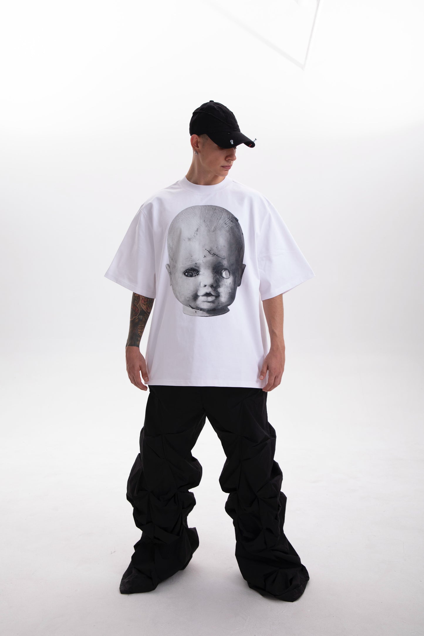 Model wearing the Baby Face white t-shirt , styled in a dark aesthetic on a white background