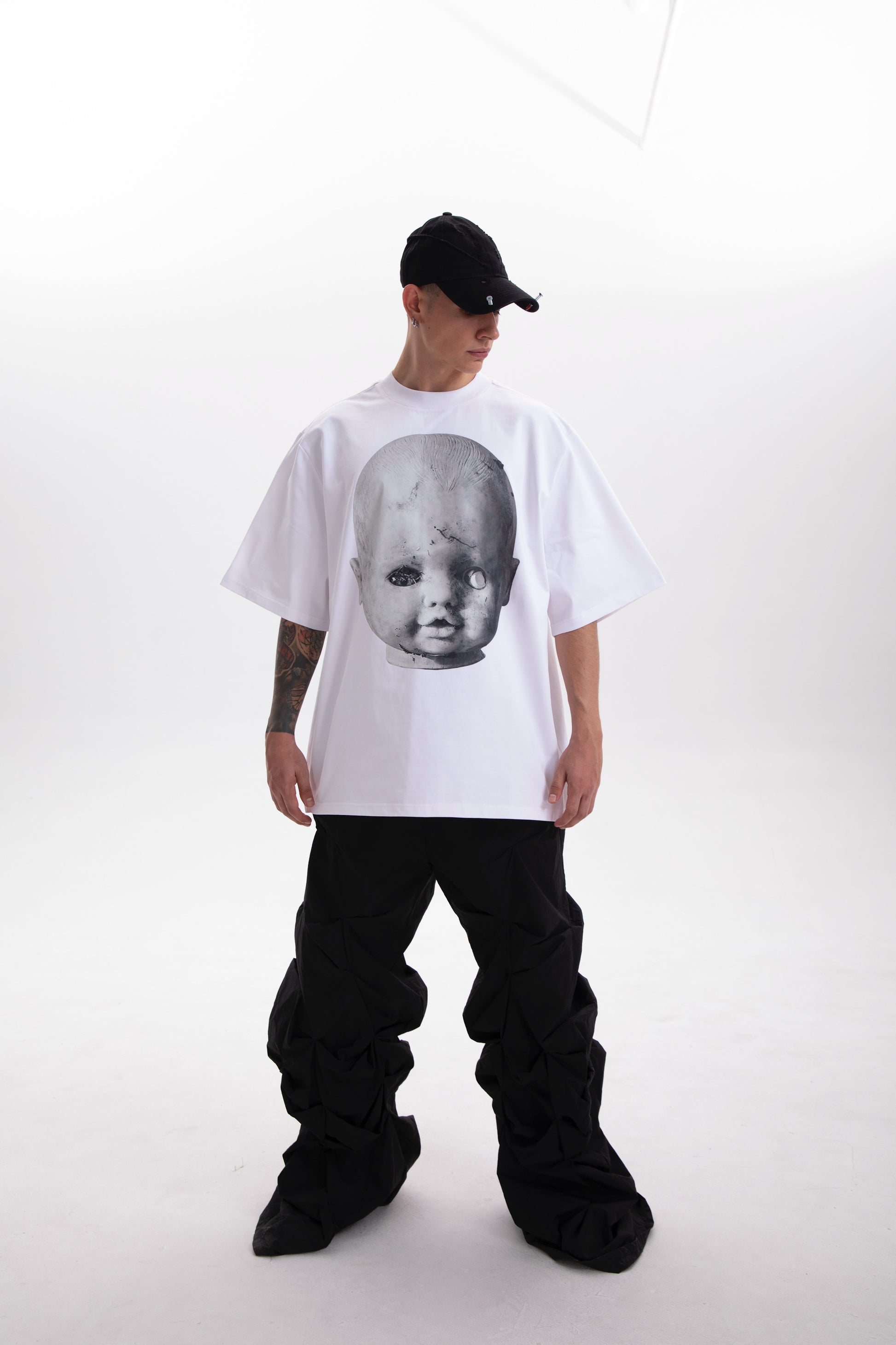 Model wearing the Baby Face white t-shirt , styled in a dark aesthetic on a white background