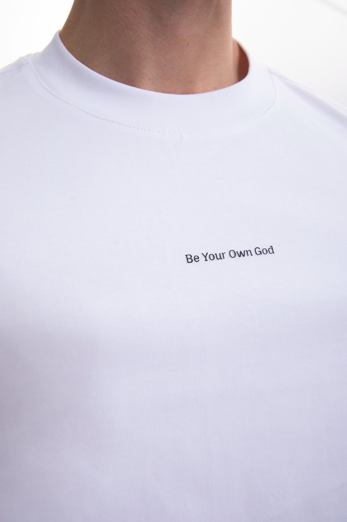 White t-shirt with 'Be Your Own God' text on a plain background