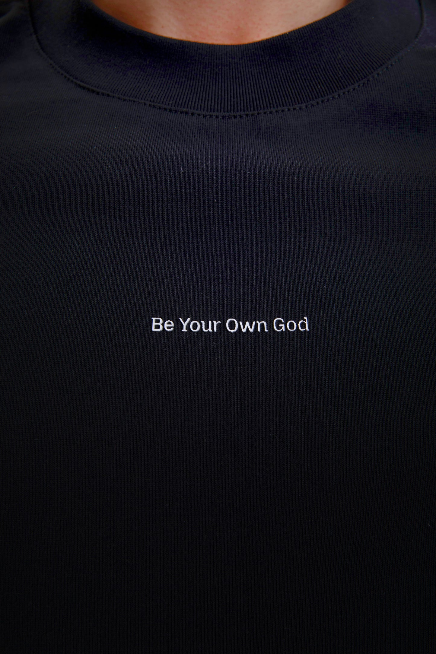 Black t-shirt with 'Be Your Own God' text in white on a plain background