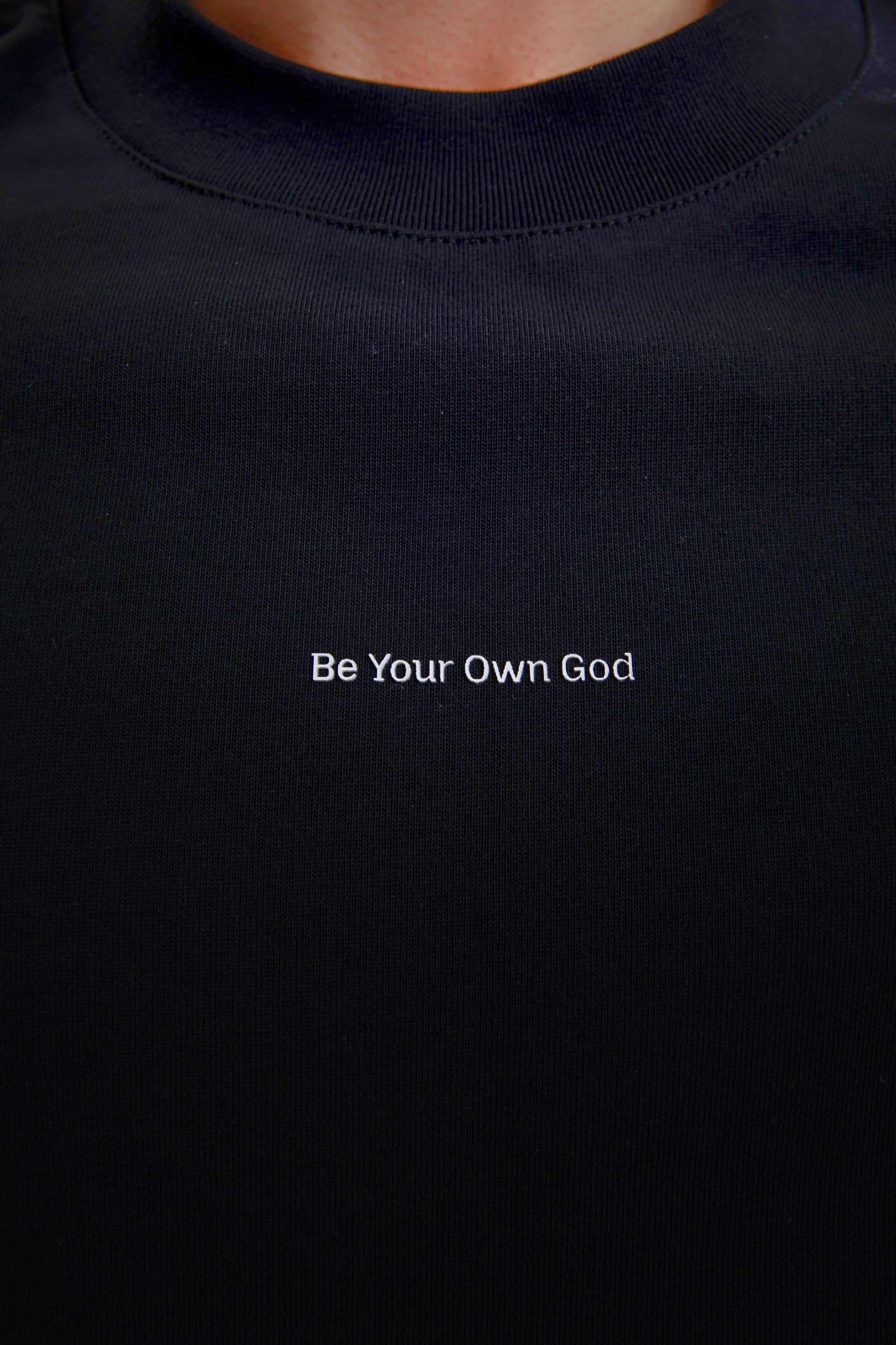 Black t-shirt with 'Be Your Own God' text in white on a plain background