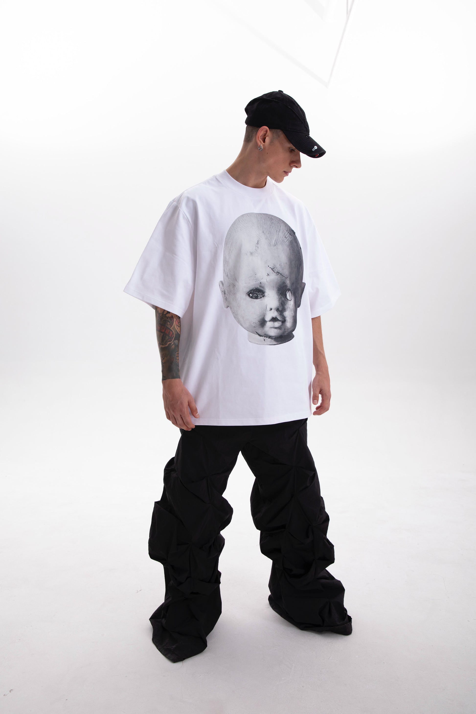 Model wearing the Baby Face white t-shirt , styled in a dark aesthetic on a white background